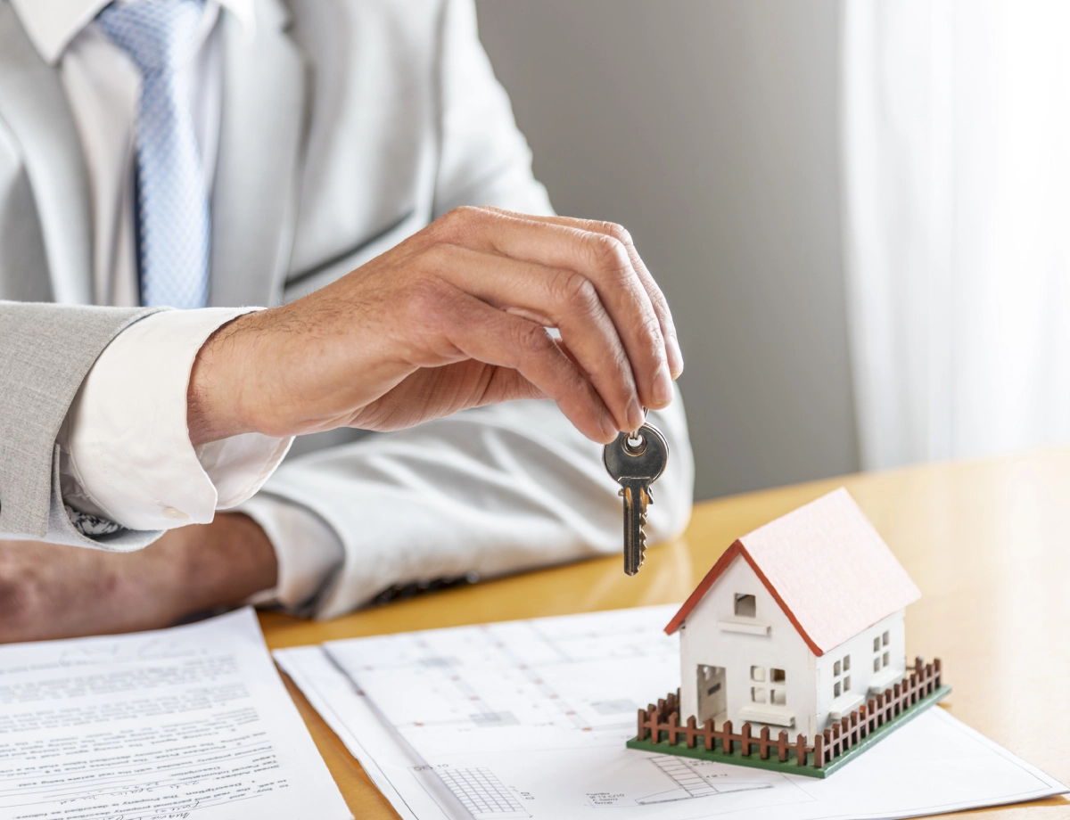 A person holding a key to a house