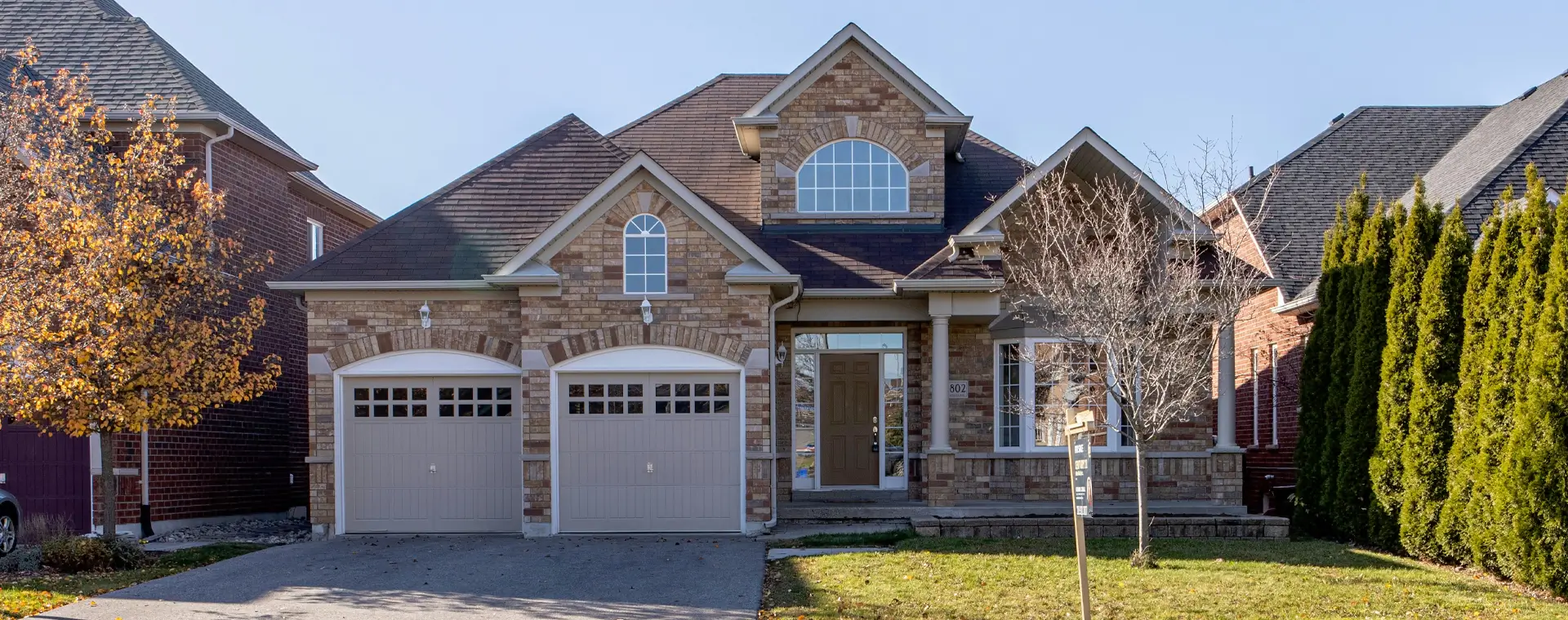 A large brick house with two garage doors.