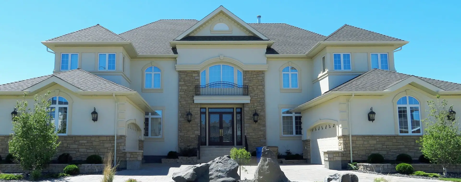 A large white house with a rock in front of it.